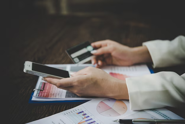 Woman holding bank card and phone, close-up view