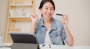 Happy woman holding a credit card