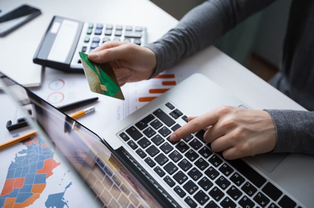 User entering credit card details on a laptop for an online purchase